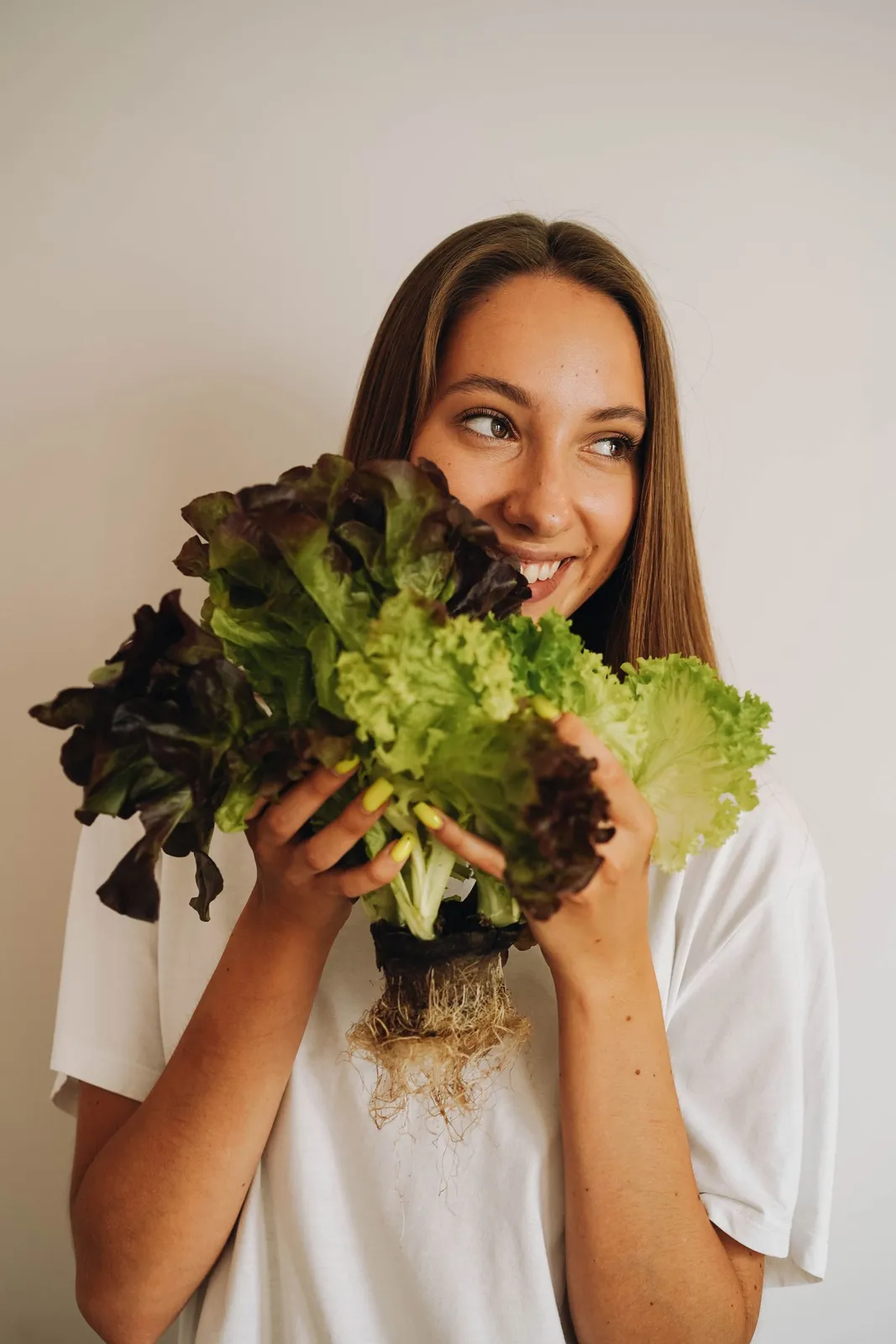 A woman holding a bunch of freshly picked lettuce